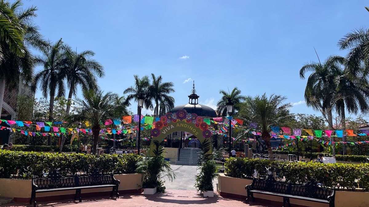 Floral entrance archway to the convention plaza, framed by palm trees