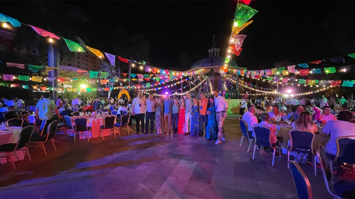 An outdoor gala dinner strung with lights and papel picado